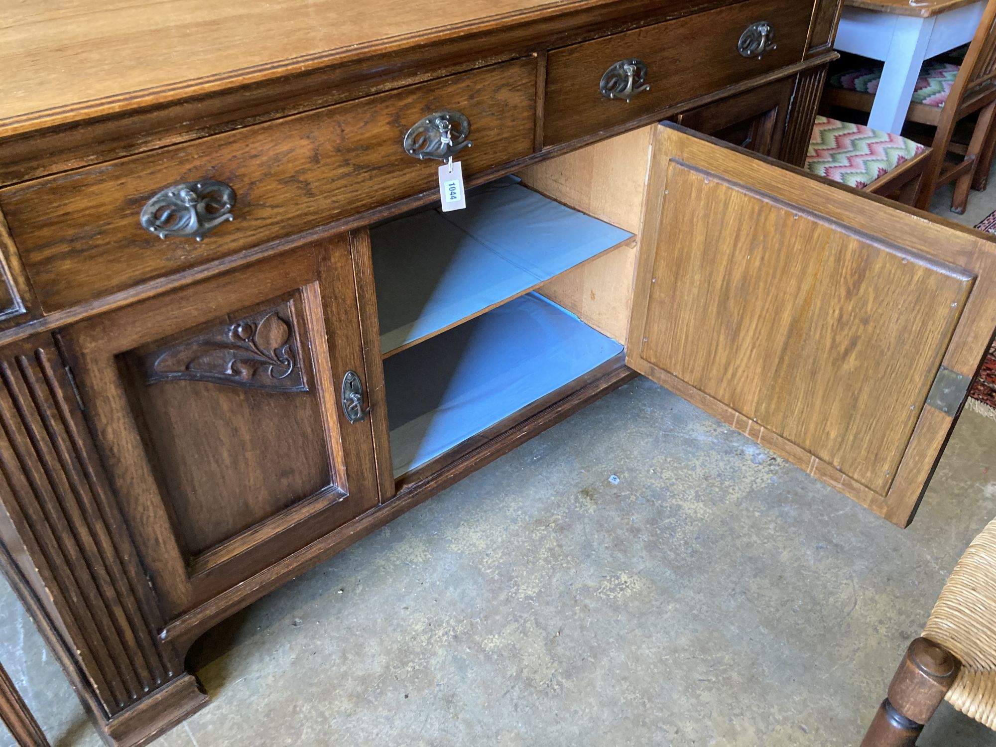 A late Victorian Art Nouveau carved oak sideboard, length 186cm, depth 62cm, height 102cm